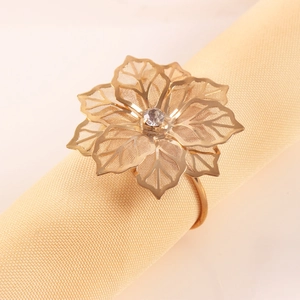 Portatovaglioli a forma di fiore dorato con cristallo su tovagliolo di beige