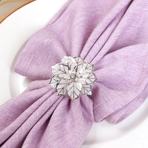 Dettaglio portatovagliolo fiore argento con petali traforati e cristallo centrale