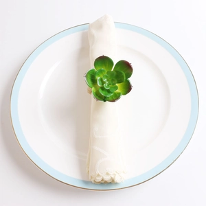 Succulent napkin ring with realistic green leaves and red tips on a beige napkin