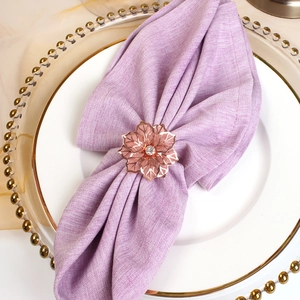 Elegante portatovagliolo in oro rosa con fiore di cristallo su piatto di porcellana