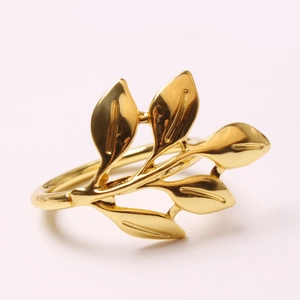 Macro detail of polished gold leaf napkin ring showcasing intricate vein texture