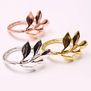 Close-up of leaf napkin rings in gold, silver, and rose gold polished metal finishes