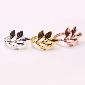 Detailed view of alloy leaf napkin rings in gold, silver, and rose gold finishes