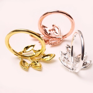 Detailed view of leaf napkin rings in gold, silver and rose gold metallic finishes