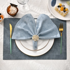 Elegant napkin ring with pearls and diamonds on blue linen napkin for wedding table decor