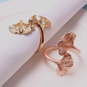 Macro shot of ginkgo leaf napkin ring set in polished gold and rose gold metal finish