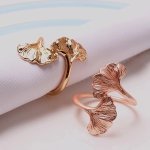 Macro detail of rose gold ginkgo leaf napkin ring with polished metal veins texture