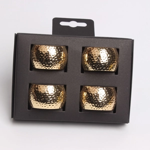 Set of 4 gold hammered metal napkin rings in black cardboard retail packaging