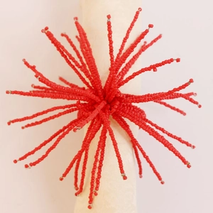 Détail du rond de serviette en perles rouges avec texture tissée radiale artistique