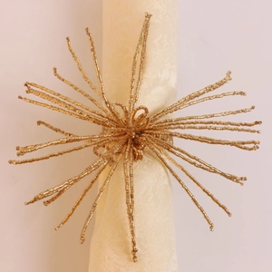 Vue de dessus d'un rond de serviette doré étoilé avec perles sur une serviette beige