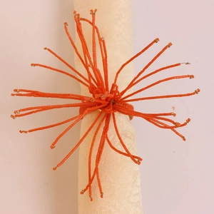 Vue de dessus du rond de serviette perlé orange avec un design en forme de corail