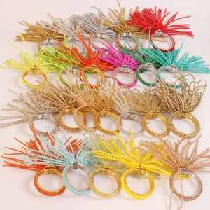 Détails de ronds de serviette en perles colorées avec pompons pour décoration de table