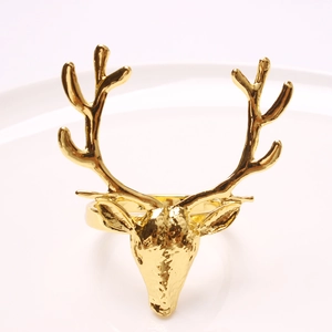 Rond de serviette renne doré sur assiette blanche pour décoration de table de Noël