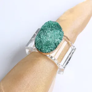 Detail of luxury green agate crystal napkin ring with gold edges on golden silk cloth