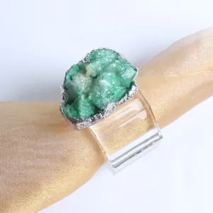Detail of green crystal napkin ring with silver trim on a gold satin napkin