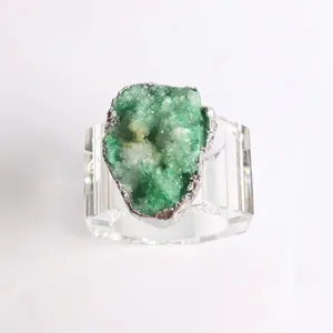 Green crystal geode napkin ring with silver trim and clear acrylic base for dining decor