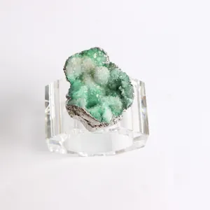 Detailed macro shot of green agate crystal napkin ring with clear geometric acrylic base