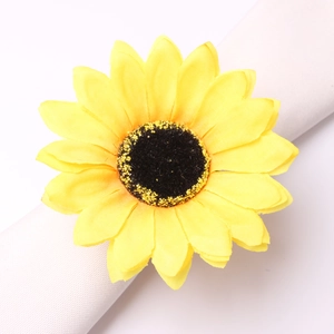 Macro detail of artificial sunflower napkin ring with realistic yellow fabric petals