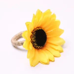 Close-up of artificial sunflower napkin ring with yellow fabric petals and jute rope