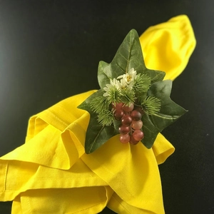 Detailed view of wedding napkin ring with white roses, ivy leaves and purple grapes