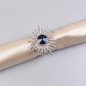 Macro shot of silver sunflower napkin ring with dark blue stone and white crystals