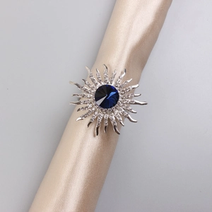 Macro detail of sunflower napkin ring with navy blue gemstone and shimmering rhinestones