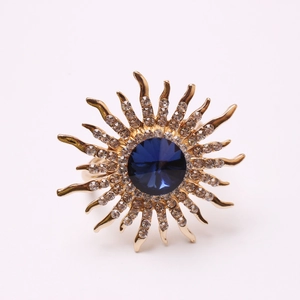 Golden sunflower napkin ring with large dark blue crystal and sparkling white rhinestones