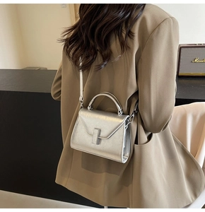Sac à main tendance en cuir métallisé argenté avec bandoulière porté à l'épaule
