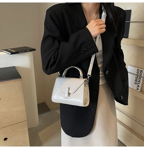 Détail du mini sac carré blanc brillant avec fermoir argenté et bandoulière