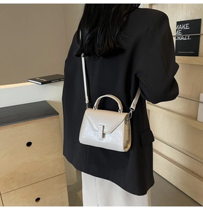 Détail du petit sac bandoulière beige minimaliste avec boucle en métal et lanière