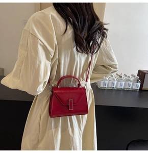 Détail du sac à main rouge brillant avec boucle métallique argentée et sa poignée
