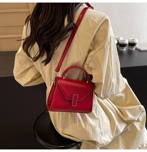 Vue détaillée d'un sac à main rouge en similicuir brillant avec boucle en métal