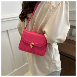 Side view of trendy rose red square crossbody bag with gold metal buckle on female model