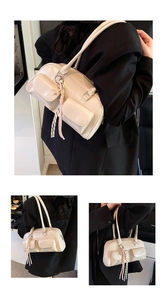 Detail of cream shoulder bag featuring double front pockets and glossy leather finish