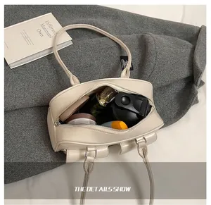 Detail showing the large interior capacity of this elegant cream leather handbag with cosmetics
