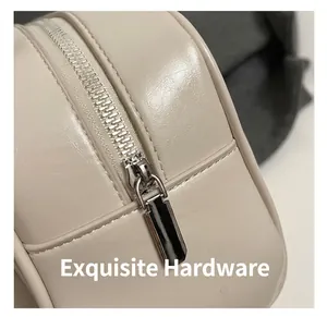 Detailed close-up of premium beige leather texture and polished silver metal zipper hardware