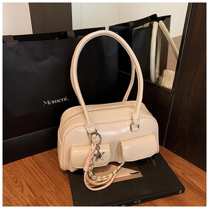 Detail of beige faux leather shoulder bag with dual front pockets and star charm
