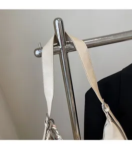 Detailed view of the beige PU leather wide shoulder strap with silver metal buckle