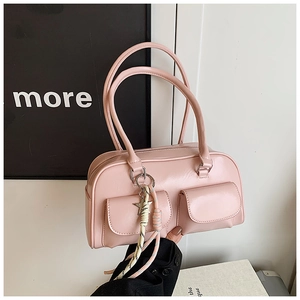 Detail of pink faux leather handbag with exterior pockets and star charm accent