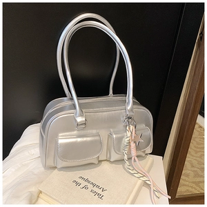 Detail of silver metallic handbag with dual flap pockets and star charm accessory