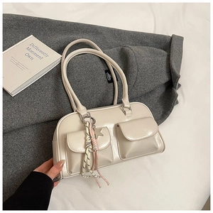 Detailed view of cream-colored glossy PU leather shoulder bag with two front pockets