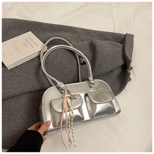 Detail of silver metallic handbag with dual front pockets and star pendant accessory