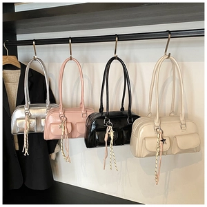 Detail of four patent leather shoulder bags in silver pink black and cream with star charms
