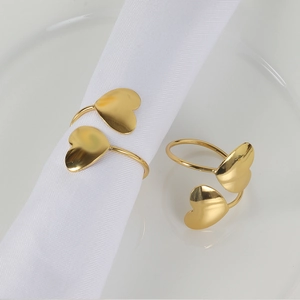 Golden heart-shaped napkin rings with pearls on white napkins for wedding table decor