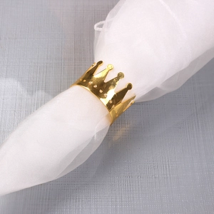 Close-up of golden crown napkin ring featuring smooth metallic finish and hollow dot details