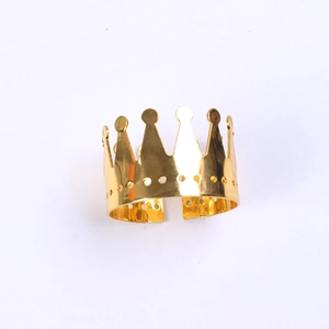 Detailed view of a gold crown-shaped napkin ring with a polished metallic finish