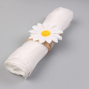 Detail of natural burlap napkin ring with lace edge and white daisy flower decoration