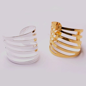 Detail of elegant gold and silver striped metal napkin rings for wedding table decor