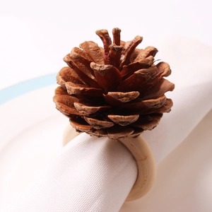 Macro shot of natural pine cone napkin ring with detailed wooden texture on white linen