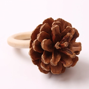 Macro detail of natural pine cone on a polished wooden napkin ring for holiday table decor